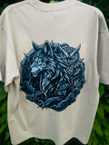An light green short-sleeve t-shirt featuring a large graphic print of a blue wolf and owl in a circular design, set against a background of green foliage.